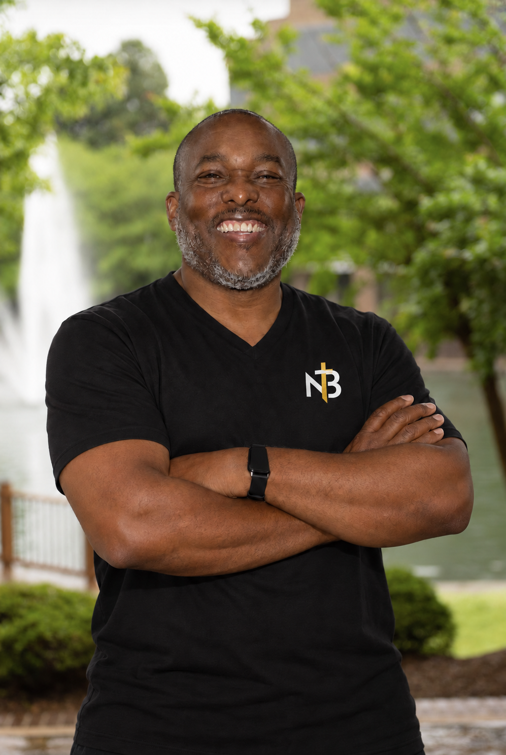 Dr. Edward Fubara smiling in a black New Breed Church V-neck shirt