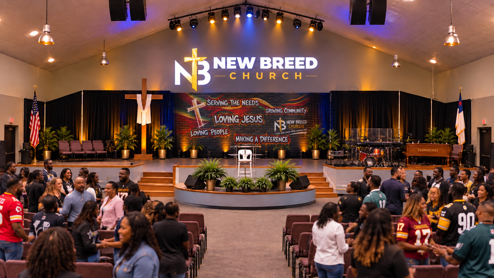 New Breed Church members greeting one another in the sanctuary, with the cross and stage in view
